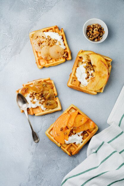 Leckere belgische Waffeln mit karamellisiertem Apfel, Birne und Walnüssen