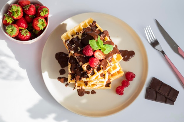 leckere belgische waffeln zum frühstück mit erdbeeren und himbeeren und schokolade