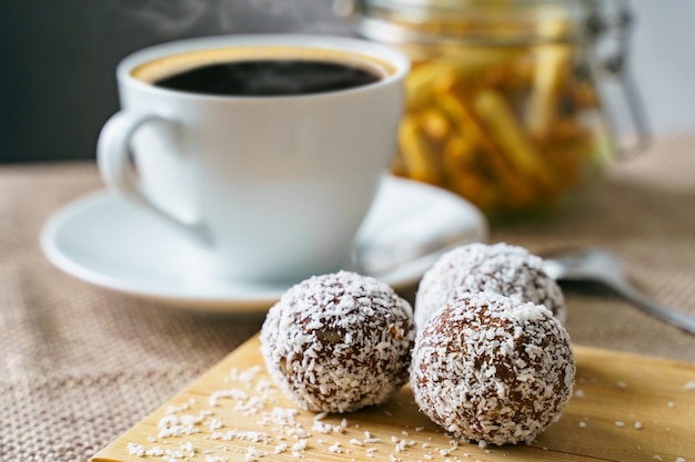 Leckere Bonbons mit Kokosnuss auf einem Holzbrett Gesundes und leckeres Frühstück