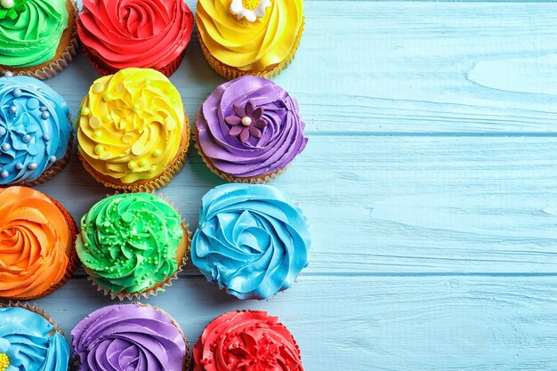 Leckere bunte Cupcakes auf Holztisch