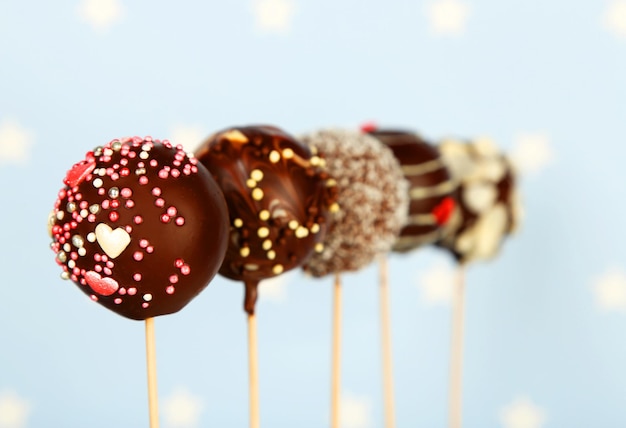 Leckere Cake Pops auf blauem Hintergrund