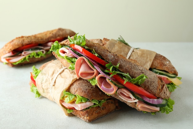 Leckere Ciabatta-Sandwiches auf weißem strukturiertem Hintergrund