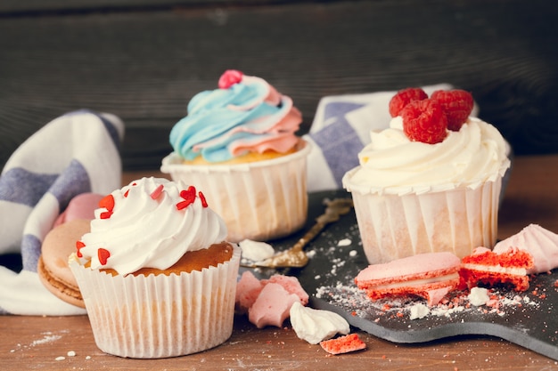 Leckere Cupcakes auf einem dunklen Holztisch