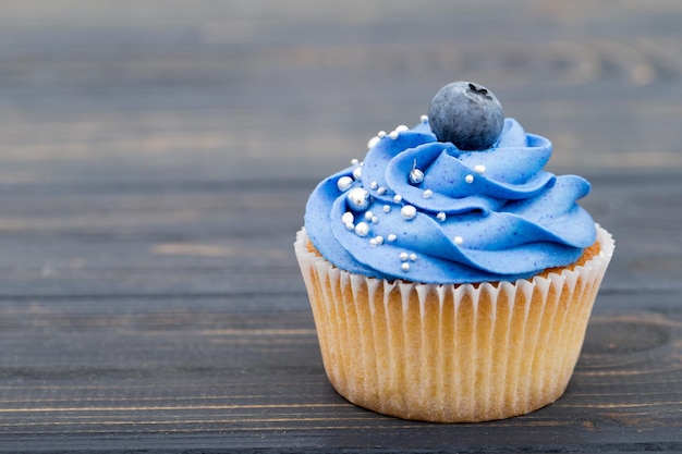 Leckere Cupcakes auf einem weißen Holztisch