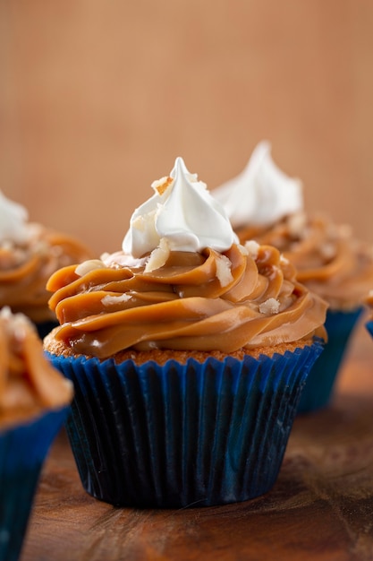 Leckere Cupcakes mit Dulce de Leche auf einem Holztisch