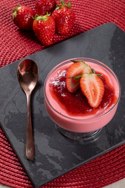 Leckere Erdbeermousse im Glas mit Marmelade obenauf.