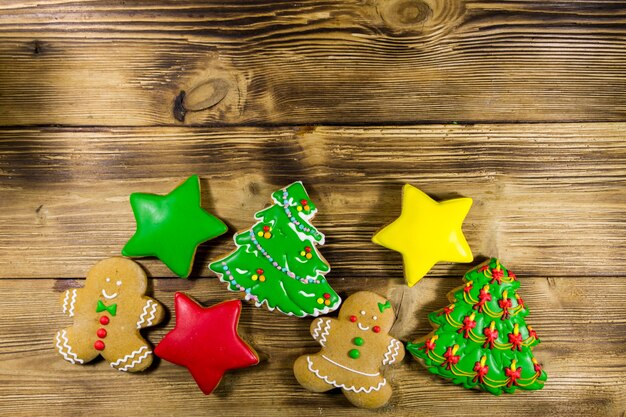 Leckere festliche Weihnachtslebkuchenplätzchen in Form von Weihnachtsbaum, Lebkuchenmann, Stern und Weihnachtssocke auf Holztisch. Ansicht von oben