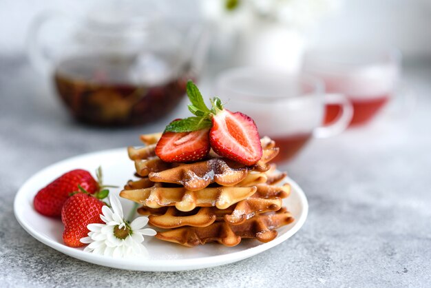 Leckere frisch gebackene belgische Waffeln mit Beeren und Früchten