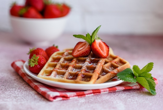 Leckere frisch gebackene belgische Waffeln mit Beeren und Früchten