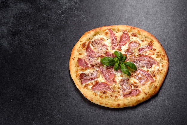 Leckere frische knusprige Pizza aus dem Ofen mit Schinken, Käse und Basilikum. italienische Küche