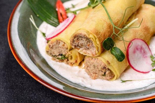 Leckere frische Pfannkuchen mit Fleisch auf einem Teller mit Gemüse und Radieschen. Leckeres herzhaftes Frühstück