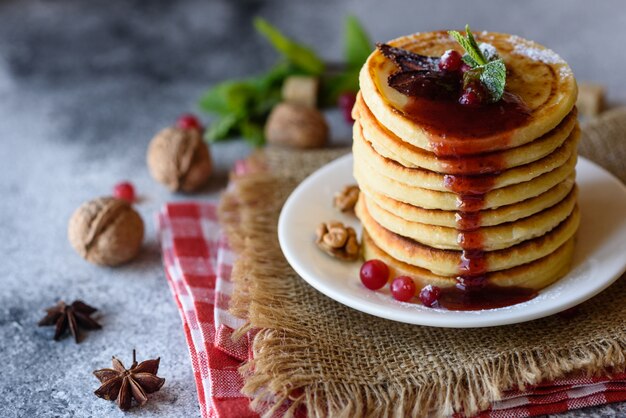 Leckere frische schöne Pfannkuchen mit Zitrushonig und Marmelade. Leckeres warmes Frühstück mit Pfannkuchen mit Obst und Beeren