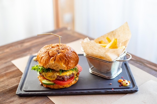 Leckere gegrillte hausgemachte Burger mit Rinder-Tomaten-Käse-Speck und Salat ungesunde Ernährung und Deto