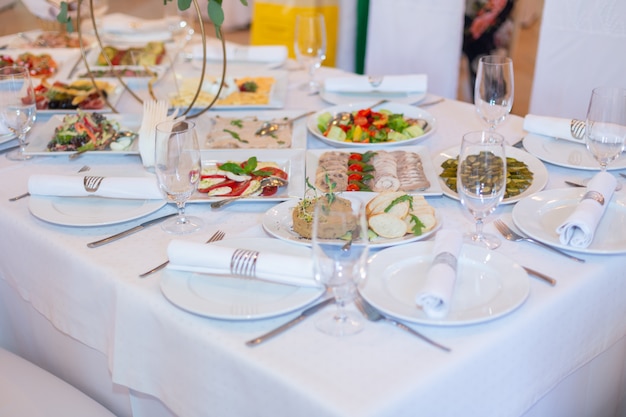 Leckere Gerichte auf einem weißen Banketttisch in einem Luxusrestaurant.