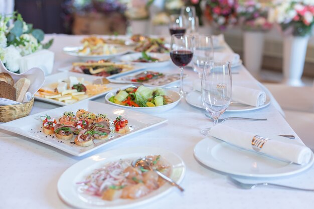 Leckere Gerichte auf einem weißen Banketttisch in einem Luxusrestaurant.