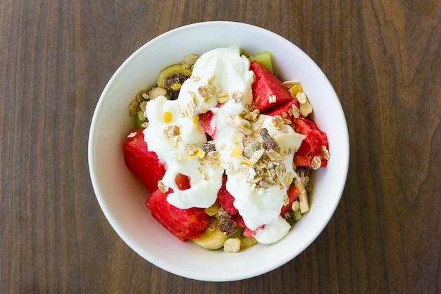 Leckere, gesunde Obstsalatschüssel mit Müsli und Joghurt zum Frühstück. Blick von oben auf den Nachtisch