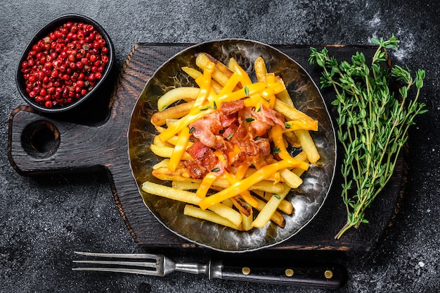 Leckere goldene Pommes Frites mit geschmolzenem Cheddar-Käse und Speck