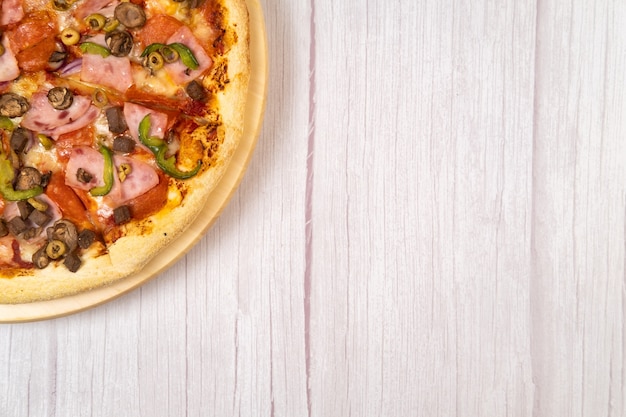 Leckere große Pizza mit Kalbfleisch und Champignons auf hellem Holzhintergrund