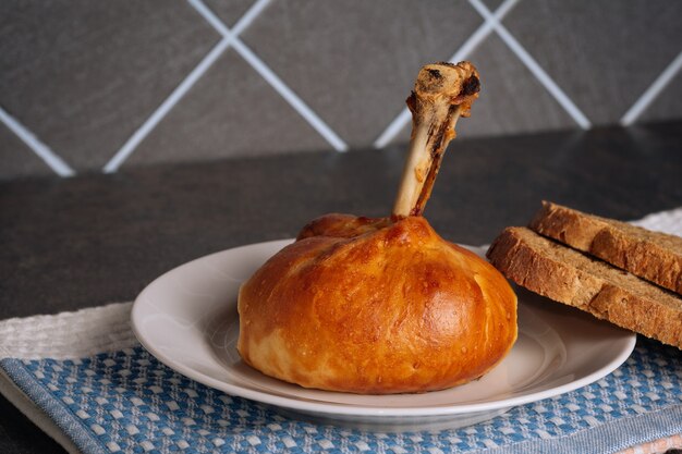 Leckere Hähnchenschenkel im Teig gebacken auf einem weißen Teller auf dunklem Hintergrund