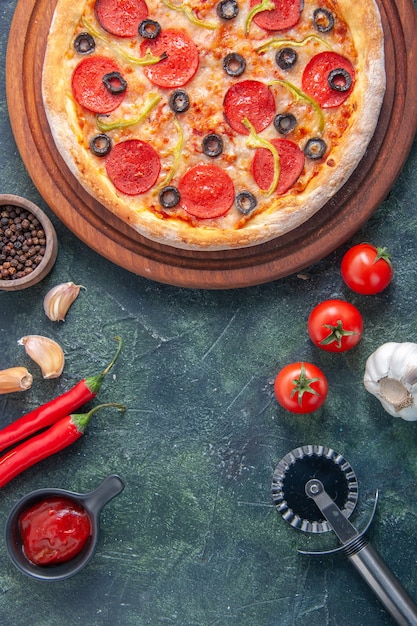 Leckere hausgemachte Pizza auf Holzbrett und Knoblauch-Tomaten-Ketchup auf isolierter dunkler Oberfläche