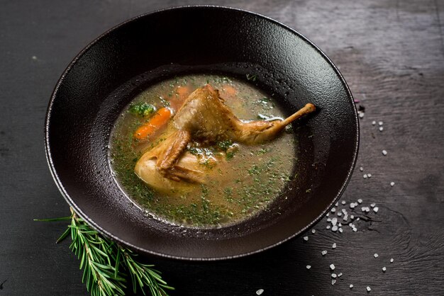 Leckere Hühnersuppe auf schwarzem Hintergrund