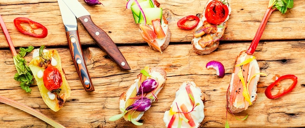 Leckere italienische Bruschetta mit Gemüse und Zutaten auf dem Küchentisch