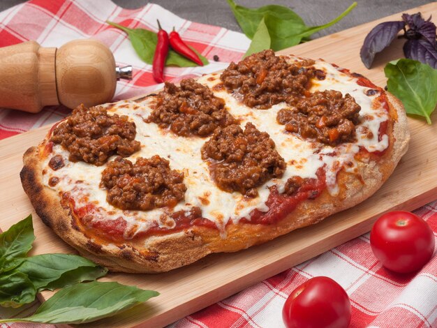 Foto leckere italienische pizza bolognese auf einem holzbrett