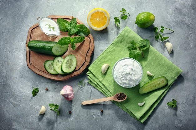 Leckere Joghurtsauce in Schüssel mit Zutaten auf dem Küchentisch kitchen