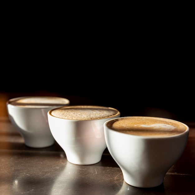 Leckere Kaffeetassen der Nahaufnahme mit Milch