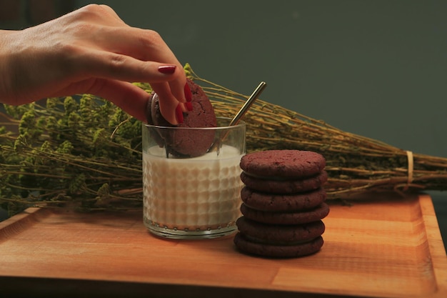 Leckere Kekse in ein Glas Milch eintauchen