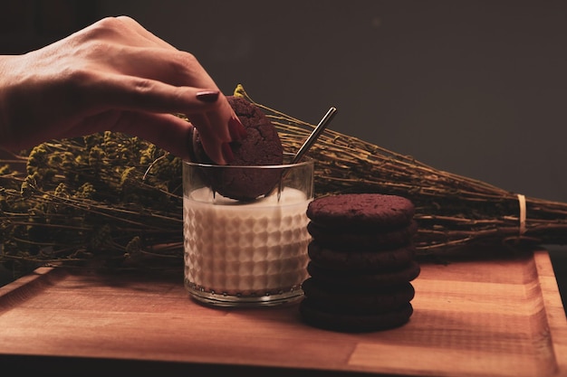 Leckere Kekse in ein Glas Milch eintauchen