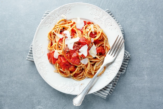 Leckere klassische italienische Pasta mit Tomatensauce und Käse auf dem Teller. Ansicht von oben.