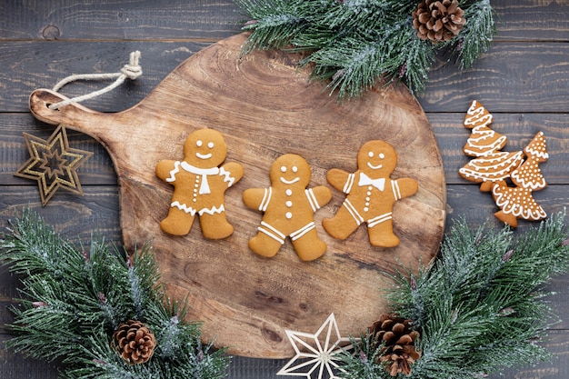 Leckere Lebkuchen und Weihnachtsdekor auf Holzhintergrund.