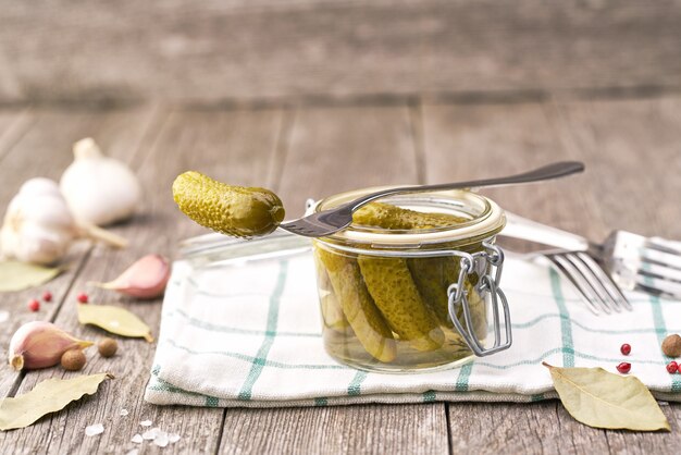 Leckere marinierte Gurken im Glas auf einem Holztisch