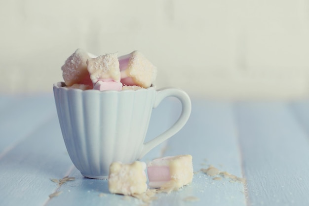 Leckere Marshmallows mit Schokolade in der Tasse auf dem Tisch aus nächster Nähe