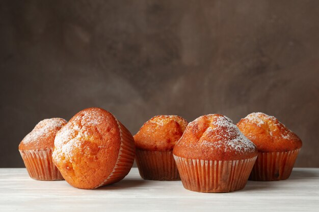 Leckere Muffins auf Holztisch gegen Braun