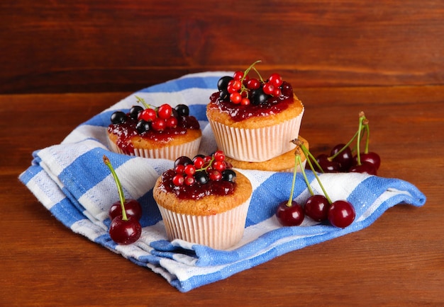 Leckere Muffins mit Beeren auf Holztisch