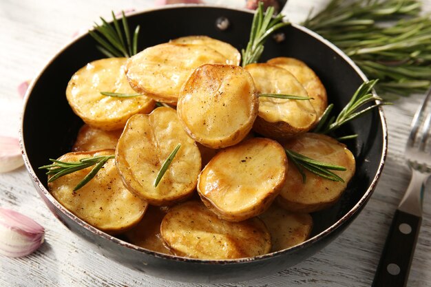 Leckere Ofenkartoffel mit Rosmarin in der Pfanne auf dem Tisch hautnah