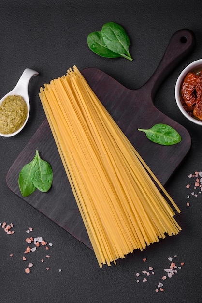 Foto leckere pasta mit spinat, sonnengetrockneten tomaten, käse, zwiebeln