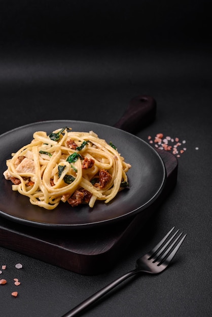 Leckere Pasta mit Spinat, sonnengetrockneten Tomaten, Käse, Zwiebeln