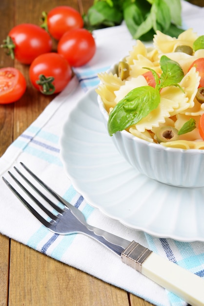 Leckere Pasta mit Tomaten auf Teller auf Tischnahaufnahme