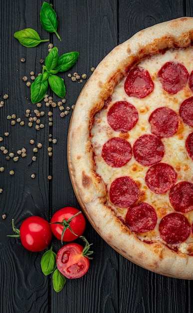 Leckere Peperoni-Pizza und Kochzutaten Tomaten-Basilikum