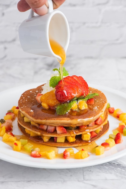 Leckere Pfannkuchen auf Marmortisch mit Früchten