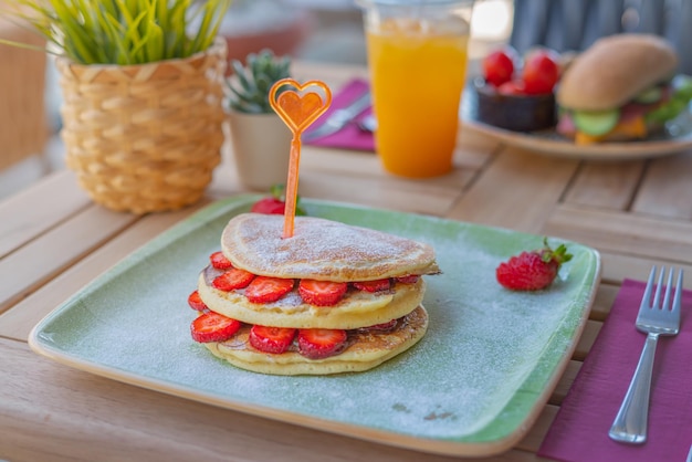 Leckere Pfannkuchen aus nächster Nähe mit frischen Erdbeeren und Schokoladensauce. Frühstückskonzept.