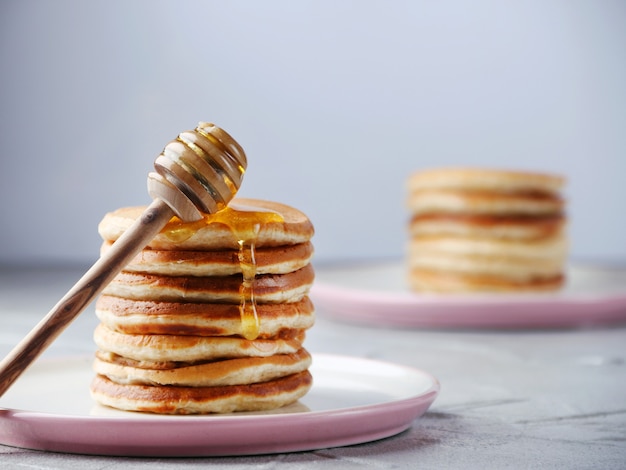 Leckere Pfannkuchen mit Honig auf dem Teller