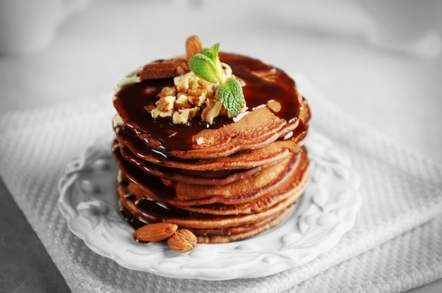 Leckere Pfannkuchen mit Nüssen und Schokoladensauce auf dem Teller