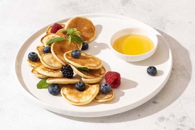 Leckere Pfannkuchen und Beeren auf weißem Teller.