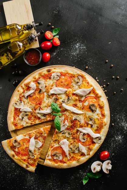 Leckere Pizza mit Hühnerfleisch auf schwarzem Hintergrund