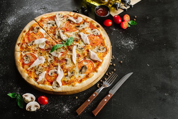 Leckere Pizza mit Hühnerfleisch auf schwarzem Hintergrund
