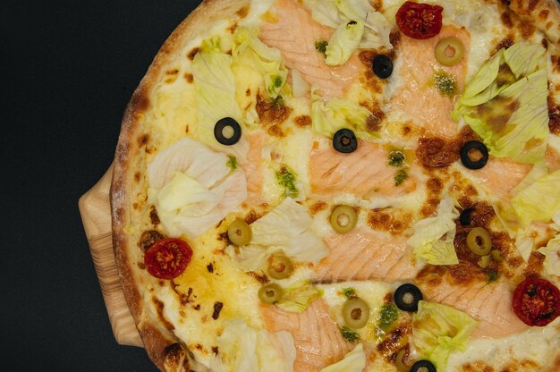 Leckere Pizza mit Lachs und Oliven